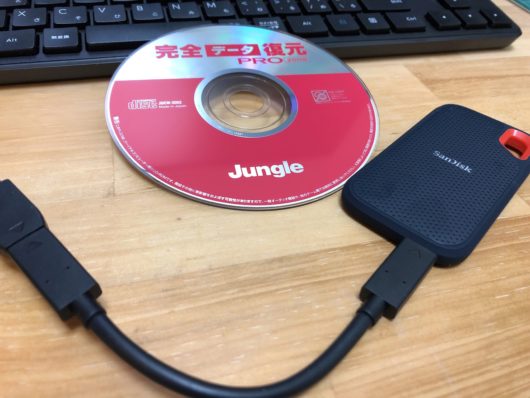 データ復旧に利用した完全復元PROと、新規で購入したSanDiskのSSDドライブ。写真の見た目以上に小さいです。名刺サイズくらいかな。